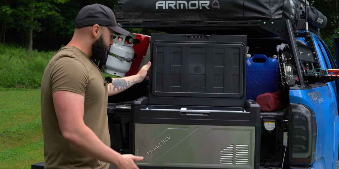 A man opening a BougeRV car fridge in his trunk