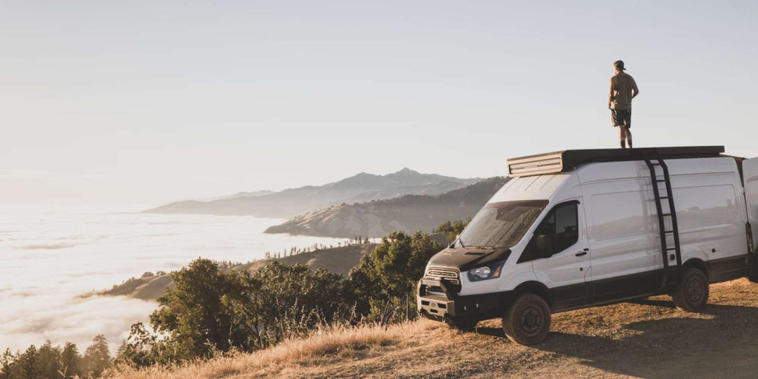A man stands atop his RV, enjoying the astonishing view