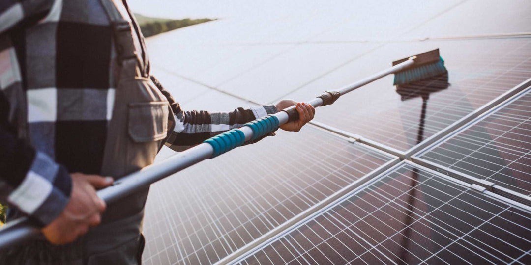 Solar worker cleaning photovoltaic panels with a brush