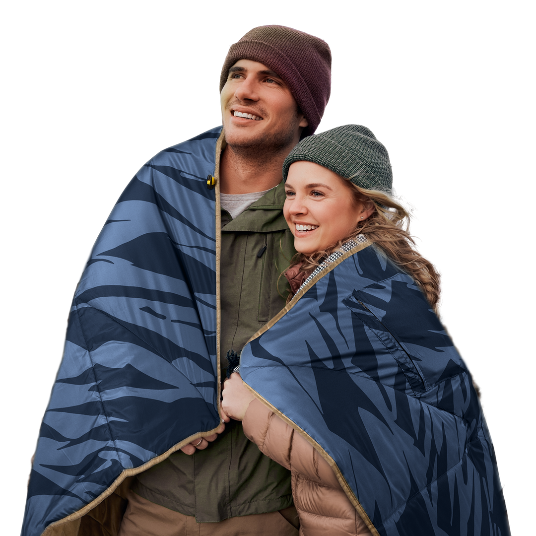 Two people wrapped in a blue-patterned 12V heated blanket