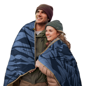 Two people wrapped in a blue-patterned 12V heated blanket
