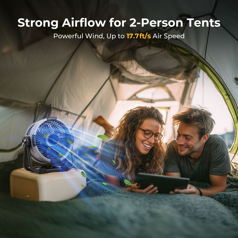 Two people inside a tent with a portable fan